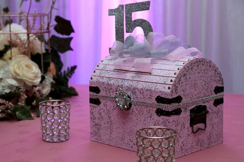 Teen birthday party Quince table decor with mock treasure chest and floral arrangement