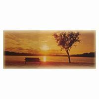 Sunset over a lake; bench, tree silhouette. Golden hour.