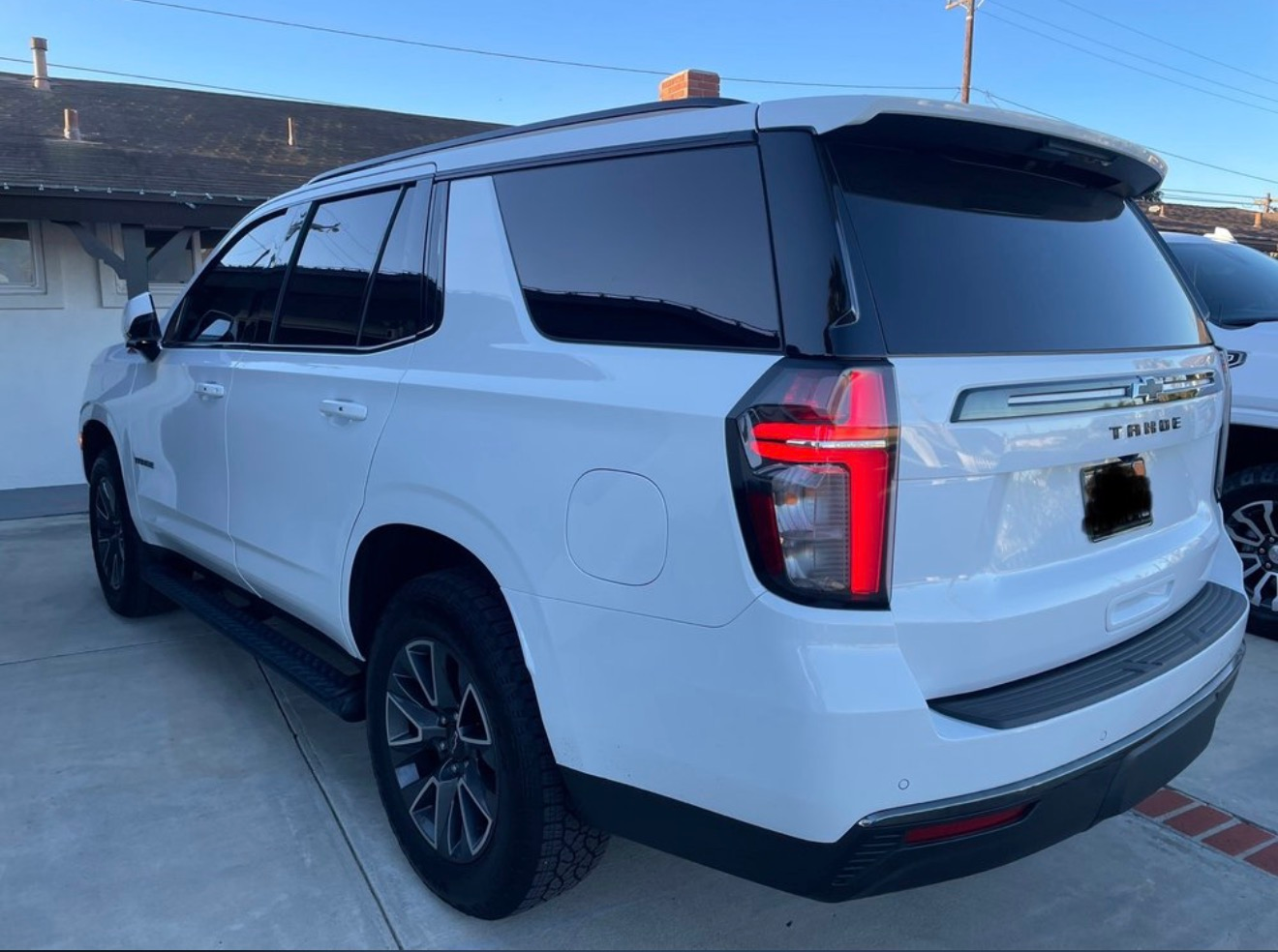 White SUV parked outdoors, rear three-quarter view, with tinted windows and black wheels.