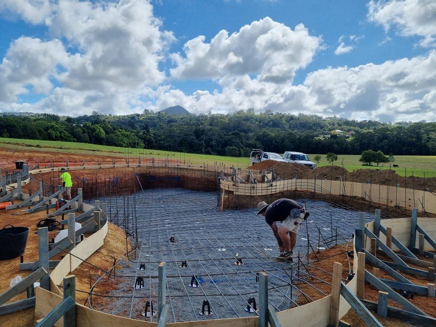 A Man Is Kneeling In The Middle Of A Pool Being Built — CJB Pools in Gympie, QLD