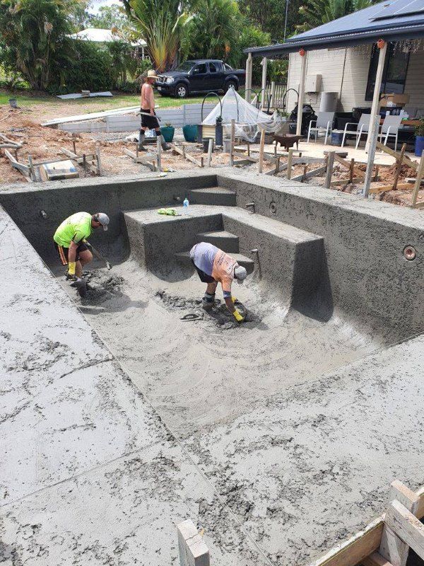 A Couple Of Men Are Working On A Swimming Pool — CJB Pools in Gympie Southside, QLD