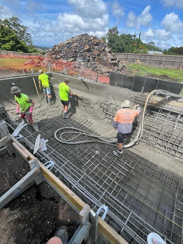 A Group Of Construction Workers Are Working On A Swimming Pool — CJB Pools in Pie Creek, QLD