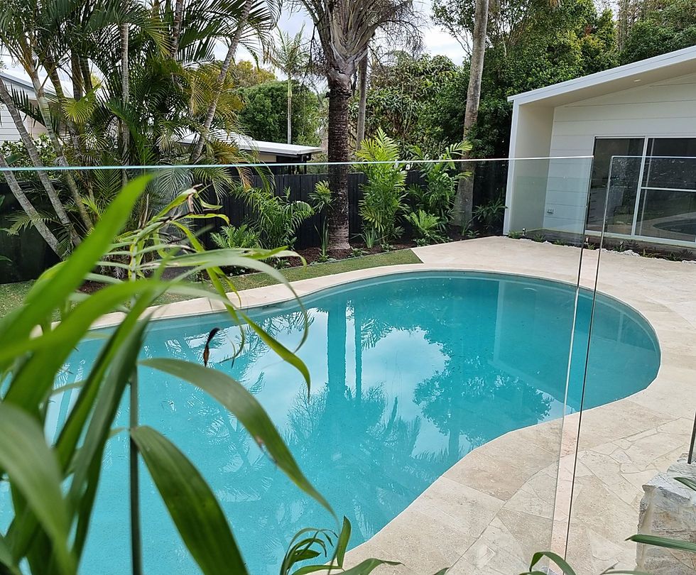 A Swimming Pool With A Palm Tree In The Middle And A House In The Background — CJB Pools in Gympie, QLD