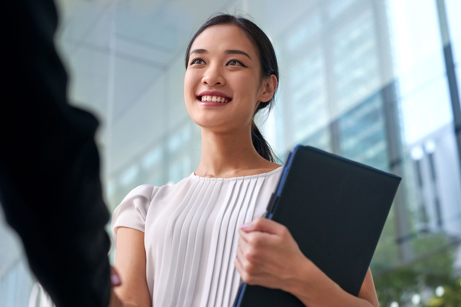 Woman smiling, holding a file