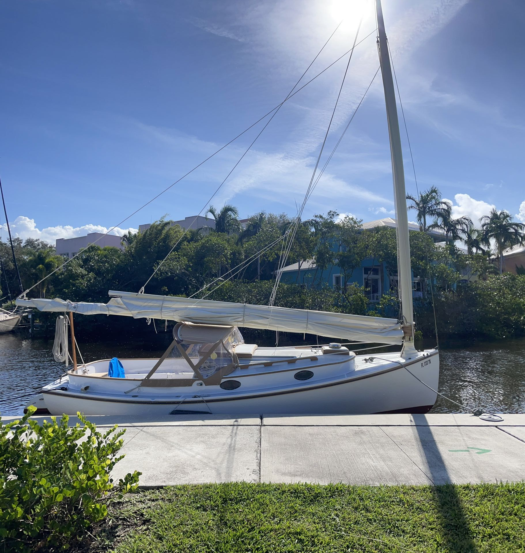 A sailboat is docked at a dock on a sunny day