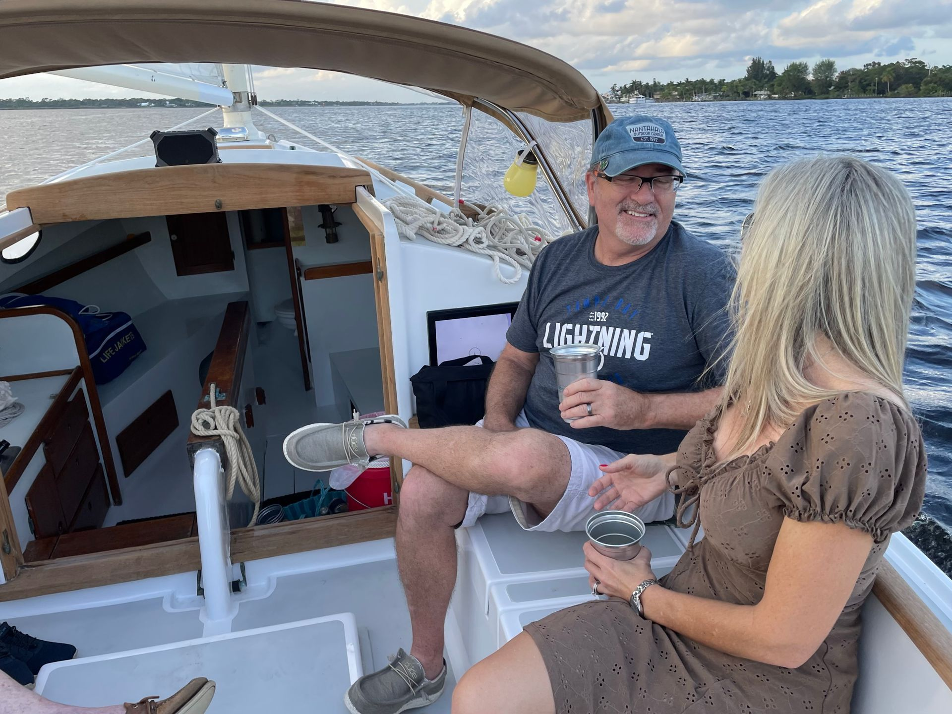 A man and a woman are sitting on a boat in the water.