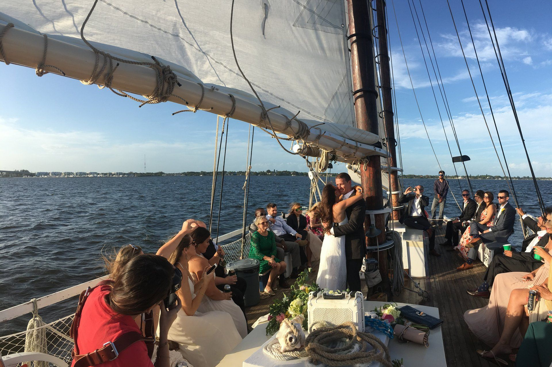 A group of people are sitting on a sailboat in the ocean.