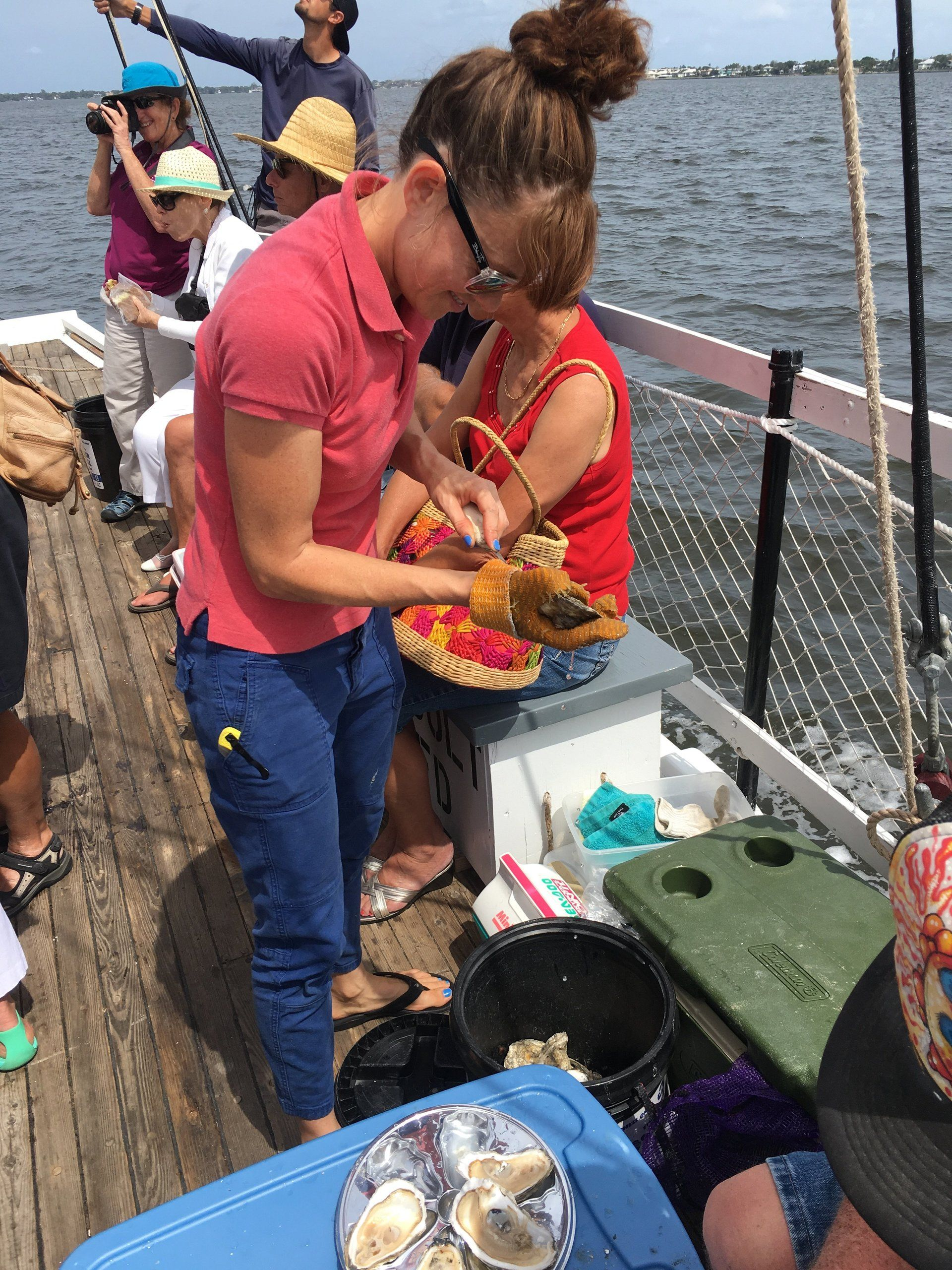 A group of people are standing on a boat eating food.
