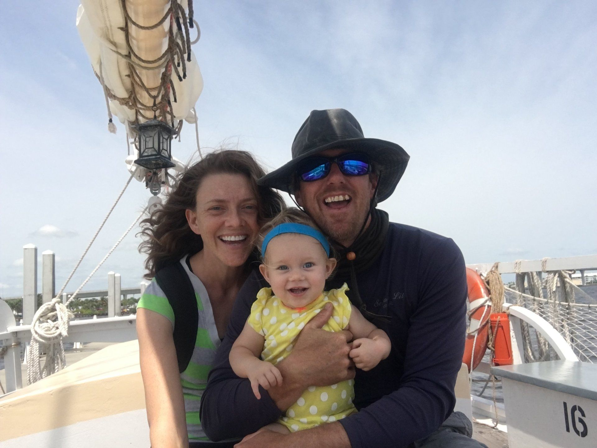 A man and woman are holding a baby on a boat.