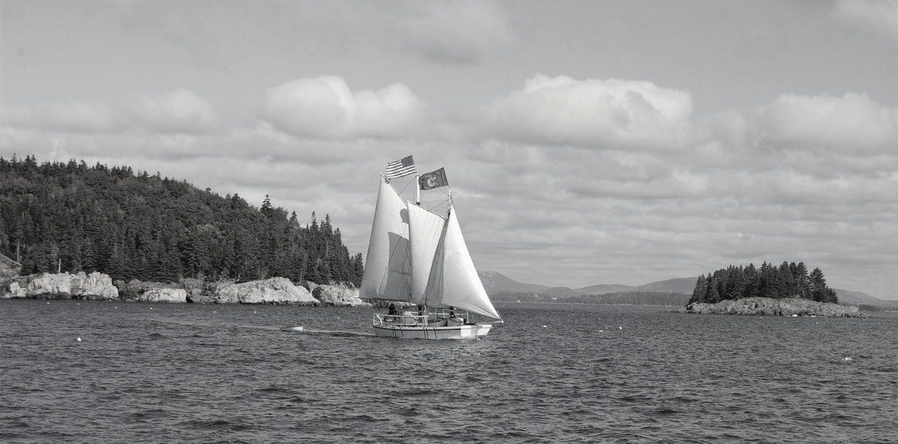 A black and white photo of a sailboat in the ocean. Schooner Lily sailing in Maine before she came to Stuart, Florida