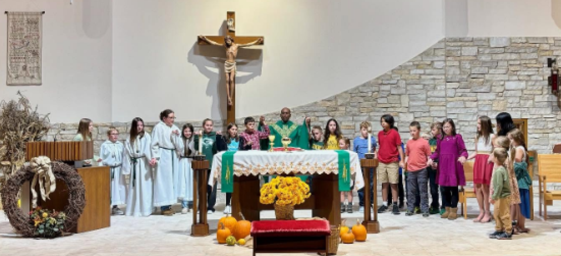 A group of children and a priest stand at an altar during a church service.