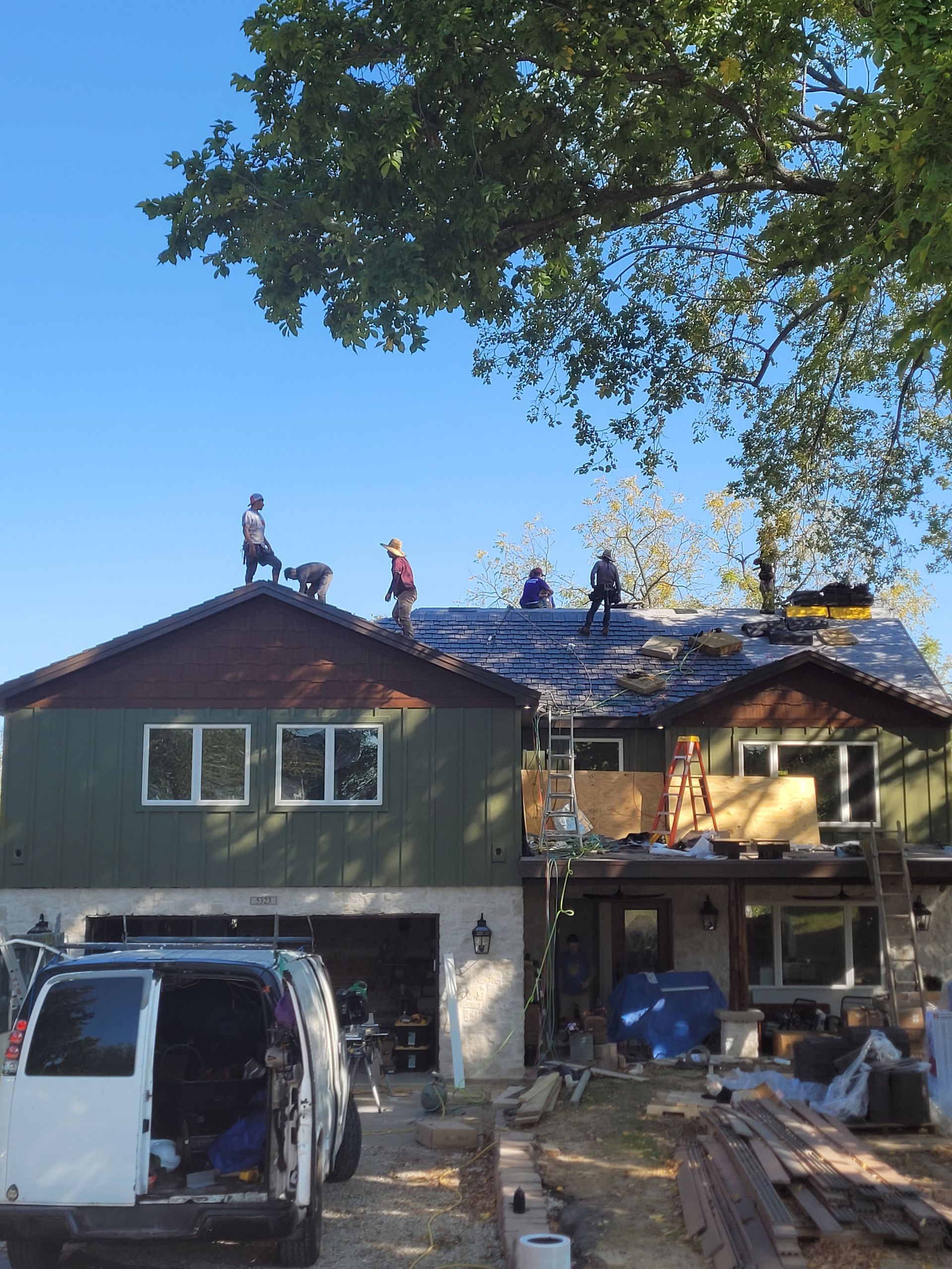 A white van is parked in front of a house under construction