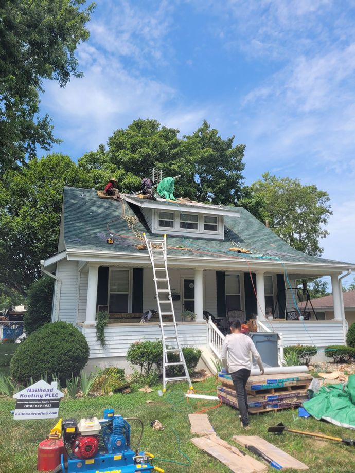A group of people are working on the roof of a house.