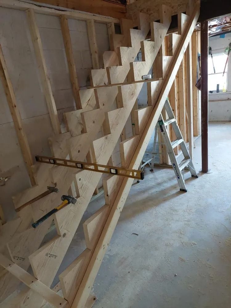 Unfinished wooden staircase under construction inside a framed house interior