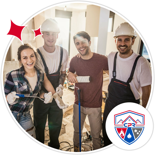 Four construction workers, three in hard hats, smile while holding painting equipment inside a renovation site.