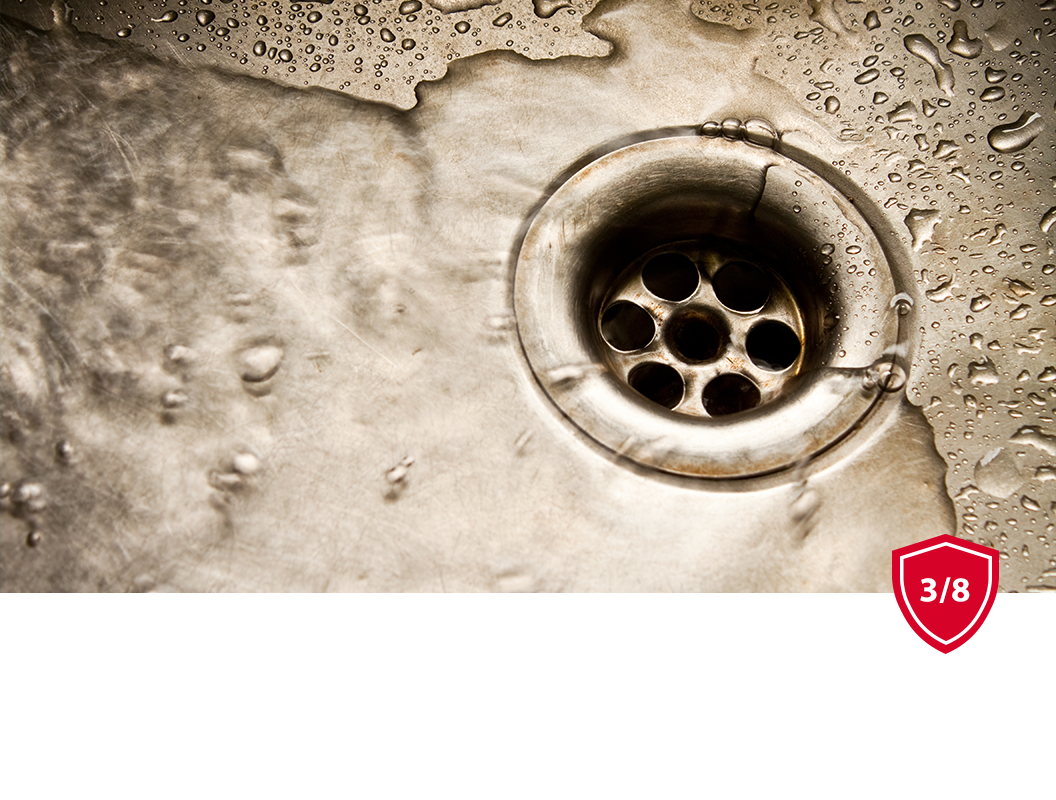 Water flows into a stainless steel sink drain.