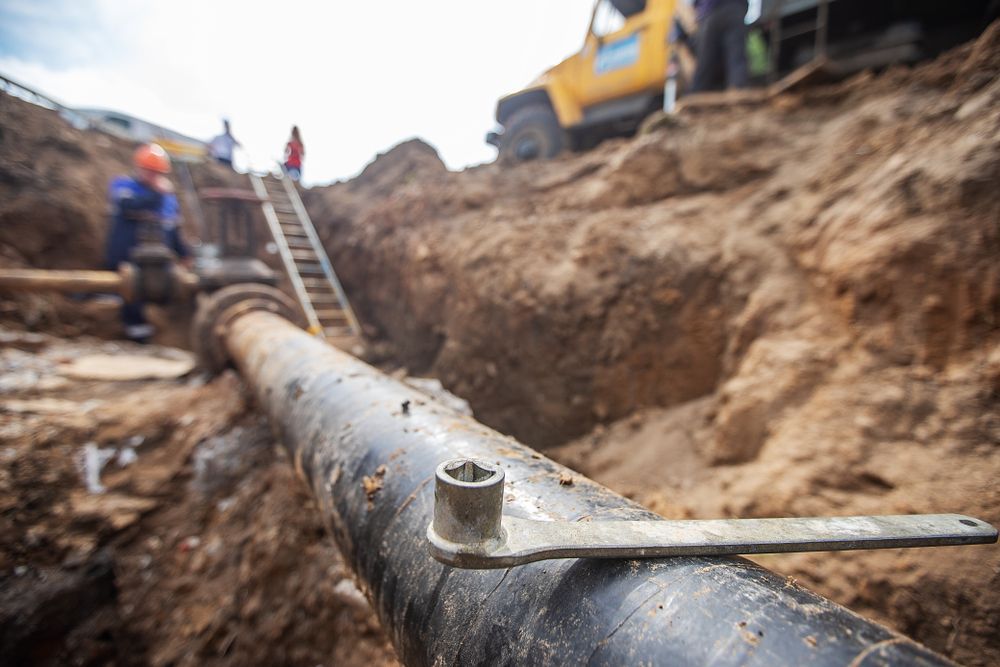 Workers Repairing a Water Pipe in a Trench — Ian Stanley Plumbing In Avoca, QLD