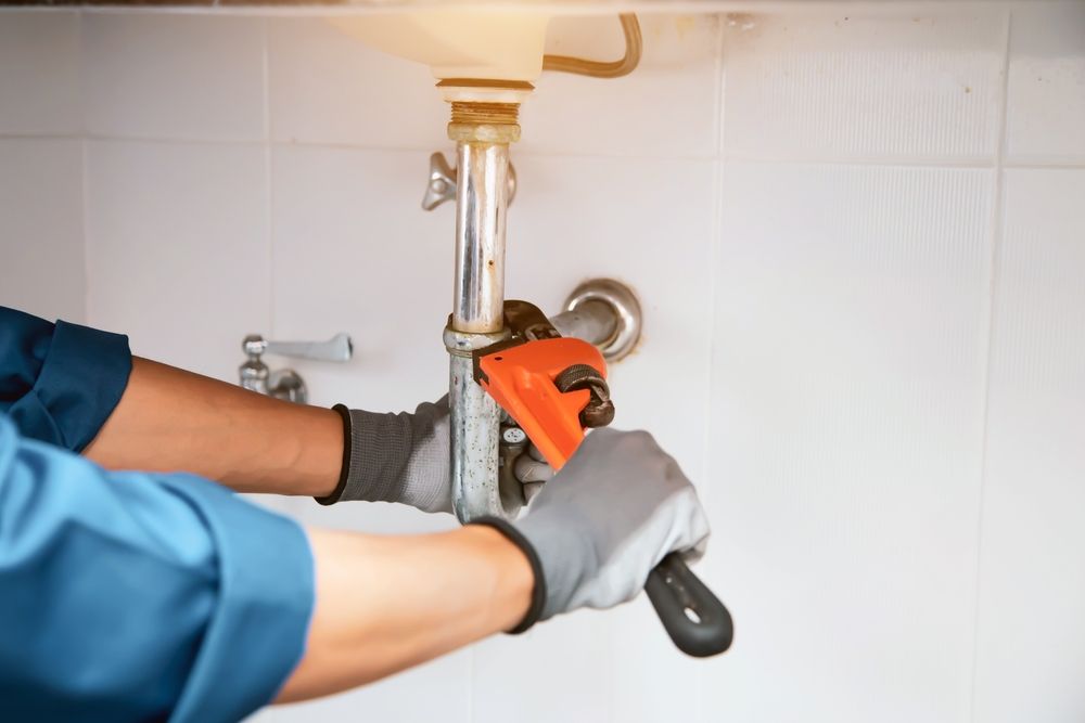 Plumber Repairing Toilet Sink — Ian Stanley Plumbing In Avoca, QLD