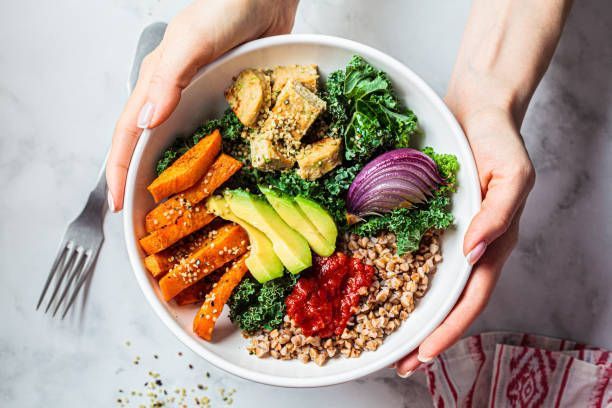 A person is holding a bowl of food with a fork.