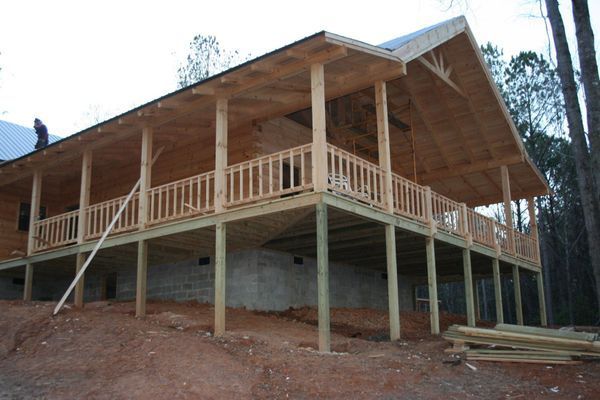 Wooden porch and deck being built on a hillside.