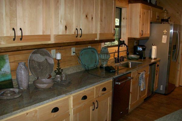 Kitchen with light wood cabinets, granite countertops, and stainless steel appliances.