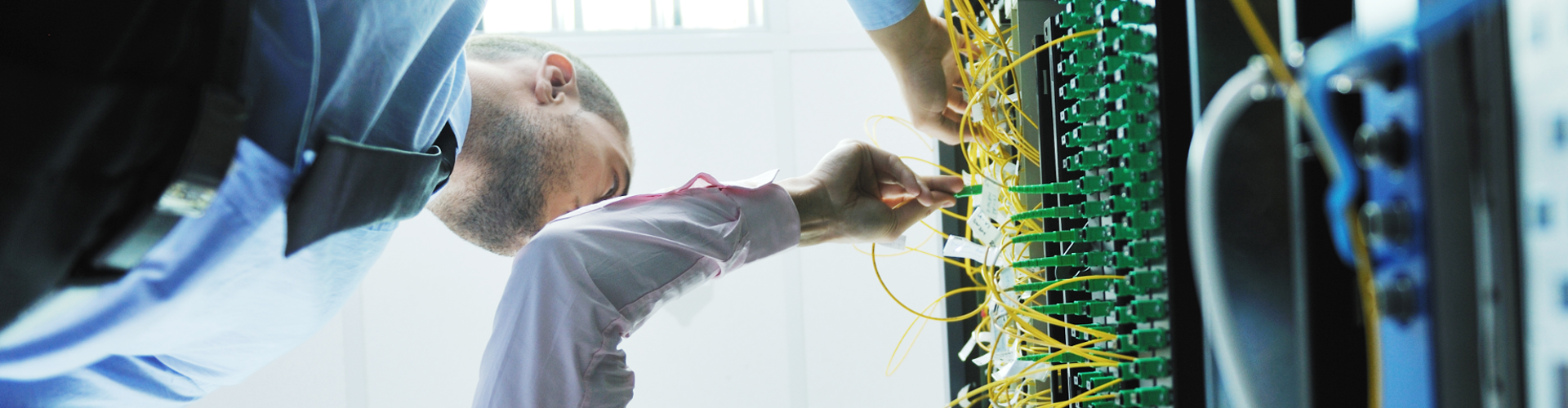 A man is working on a server in a data center.