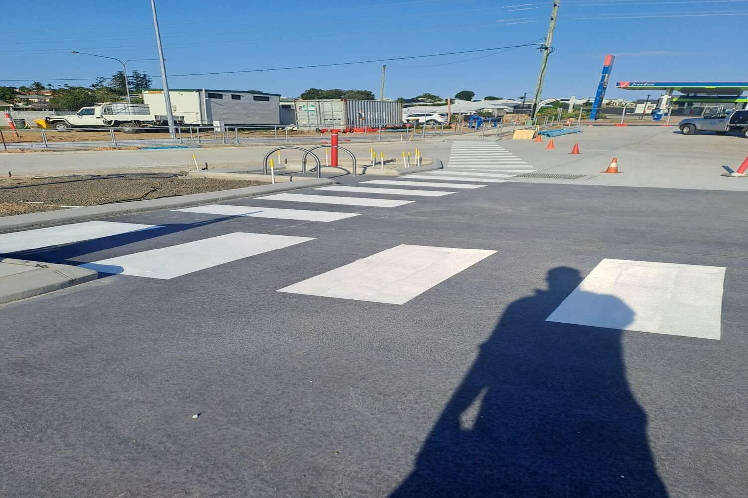 A Shadow Of A Person Is Cast On A Crosswalk In A Parking Lot — Spraywayz Linemarking Pty Ltd In Booral, QLD