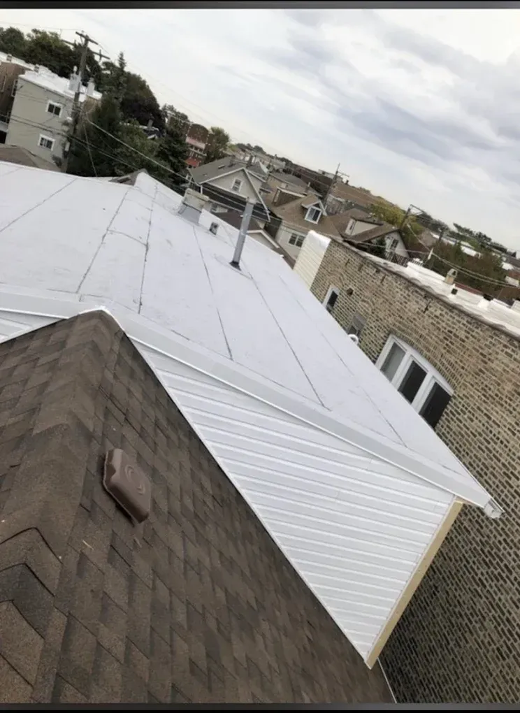 Tilted view of white and brown residential rooftops and siding on a cloudy day