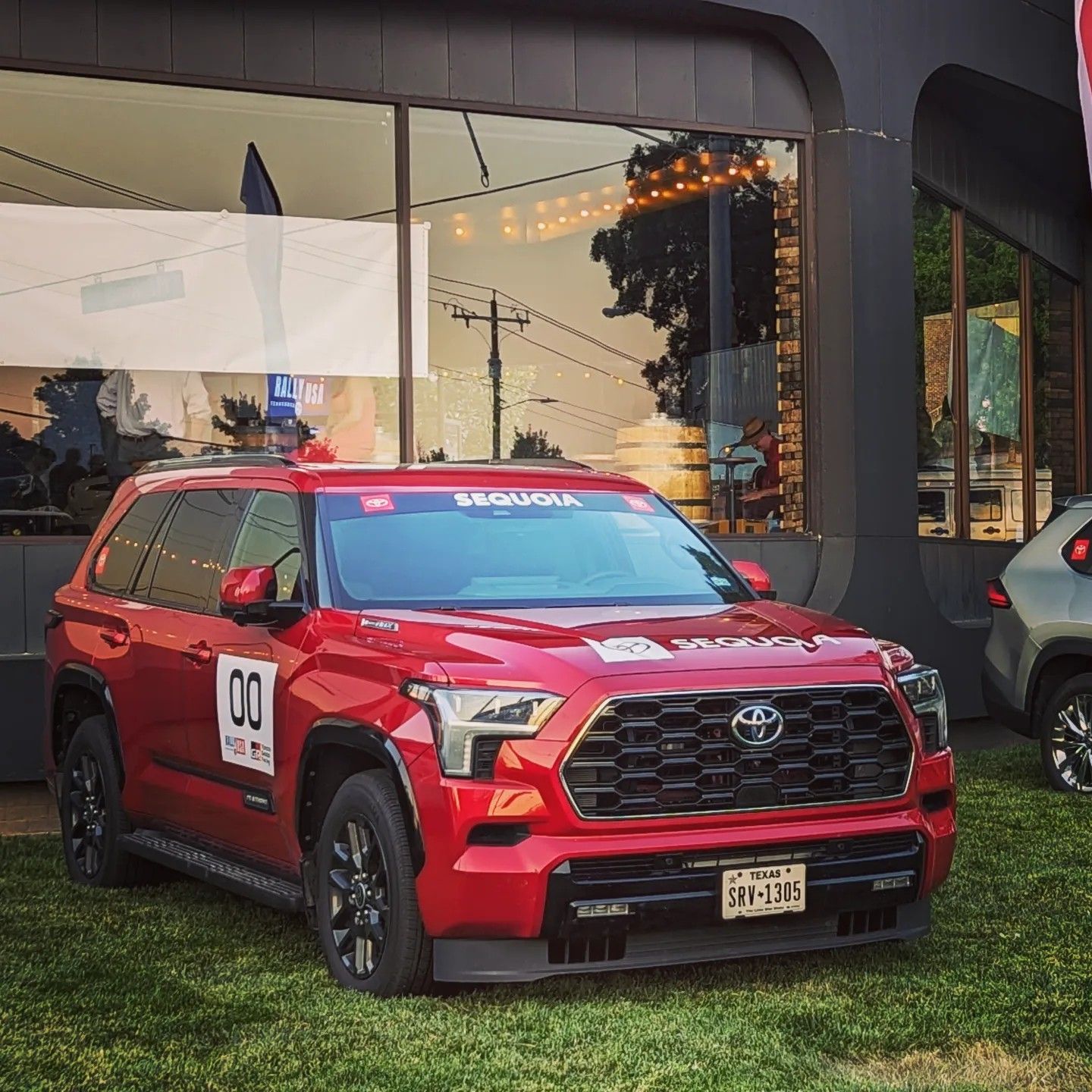 A red toyota tundra is parked in front of a building
