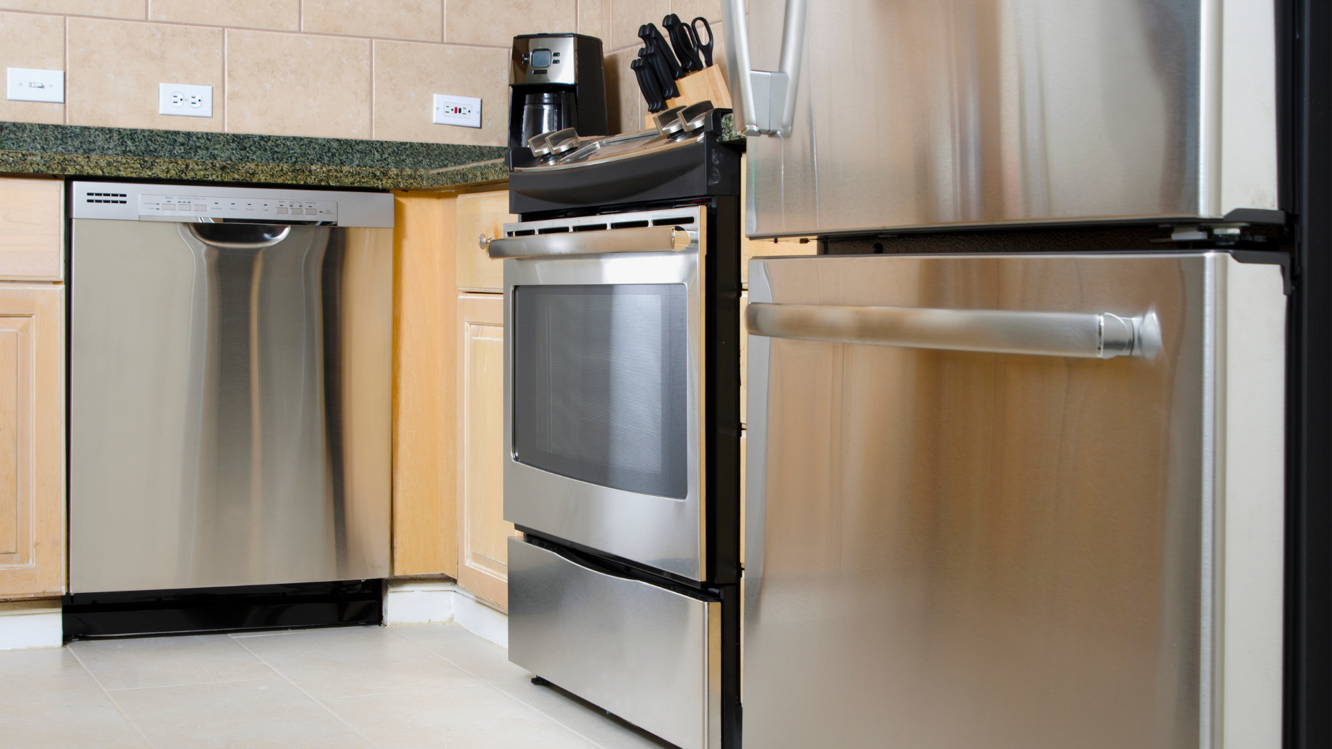 Stainless steel kitchen appliances, including dishwasher, oven, and refrigerator, in a modern kitchen