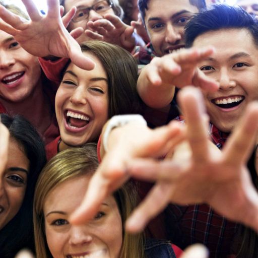 Portrait of large group of students cheering at college sporting event