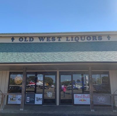 The front of an old west liquor store with a blue sky in the background.