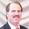A man in a suit and tie is smiling for the camera.