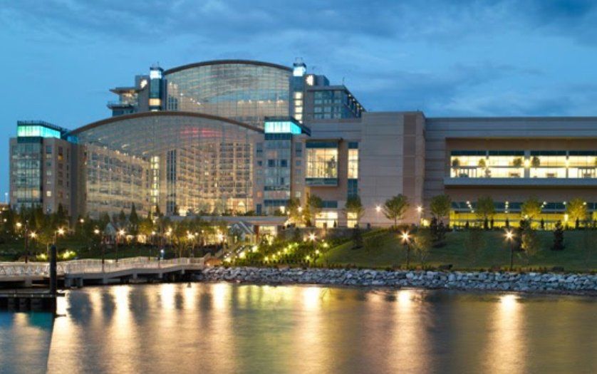 A large building is lit up at night next to a body of water.