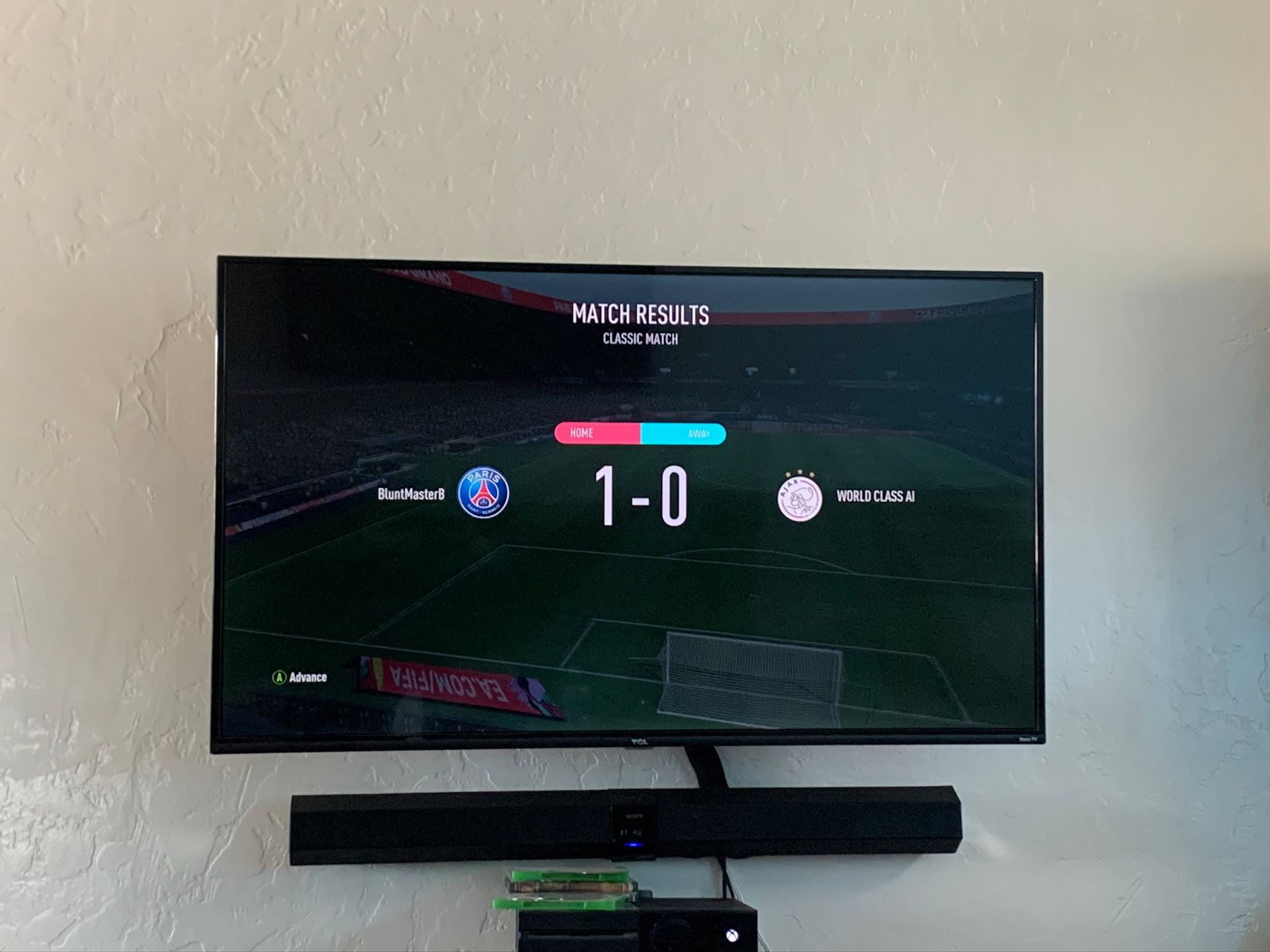 Soccer game score: PSG 1, opponent 0, displayed on a TV mounted on a wall.