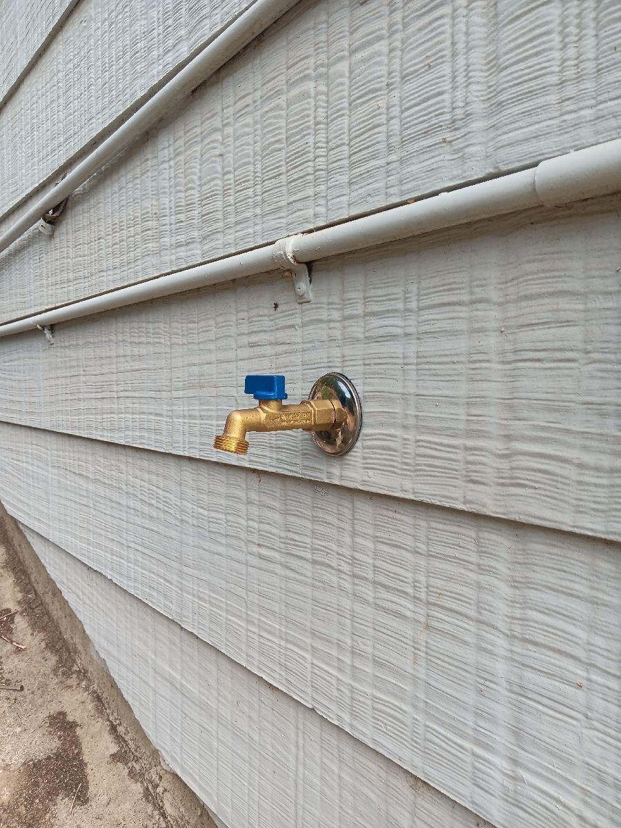 A Brass Outdoor Faucet With a Small Blue Handle — Dunnrite Plumbing Services in Cannonvale, QLD