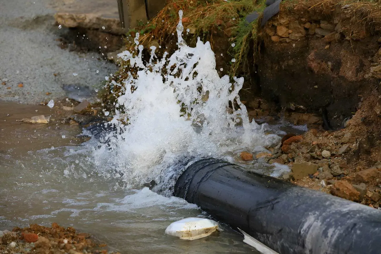 Water Forcefully Spraying From a Broken Dark Pipe — Dunnrite Plumbing Services in Cannonvale, QLD