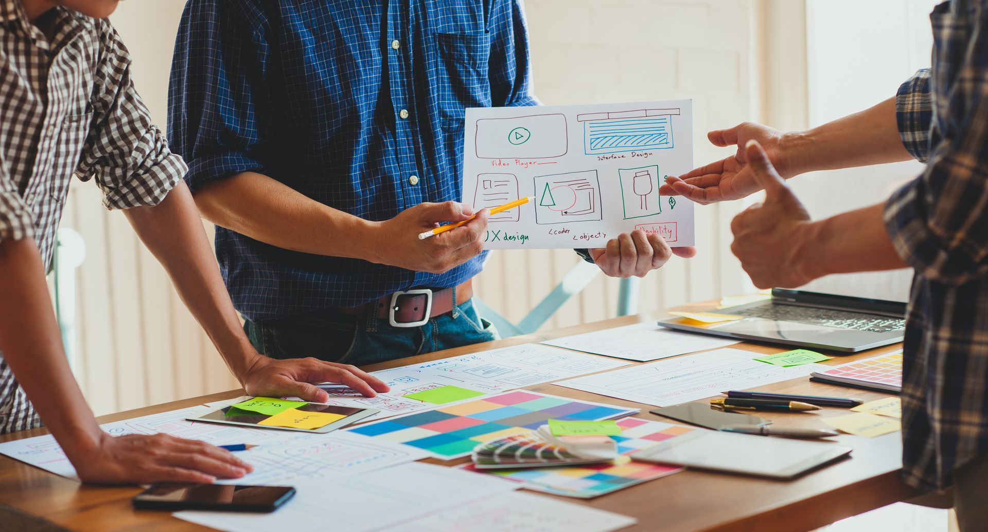 A group of people are standing around a table looking at a piece of paper.