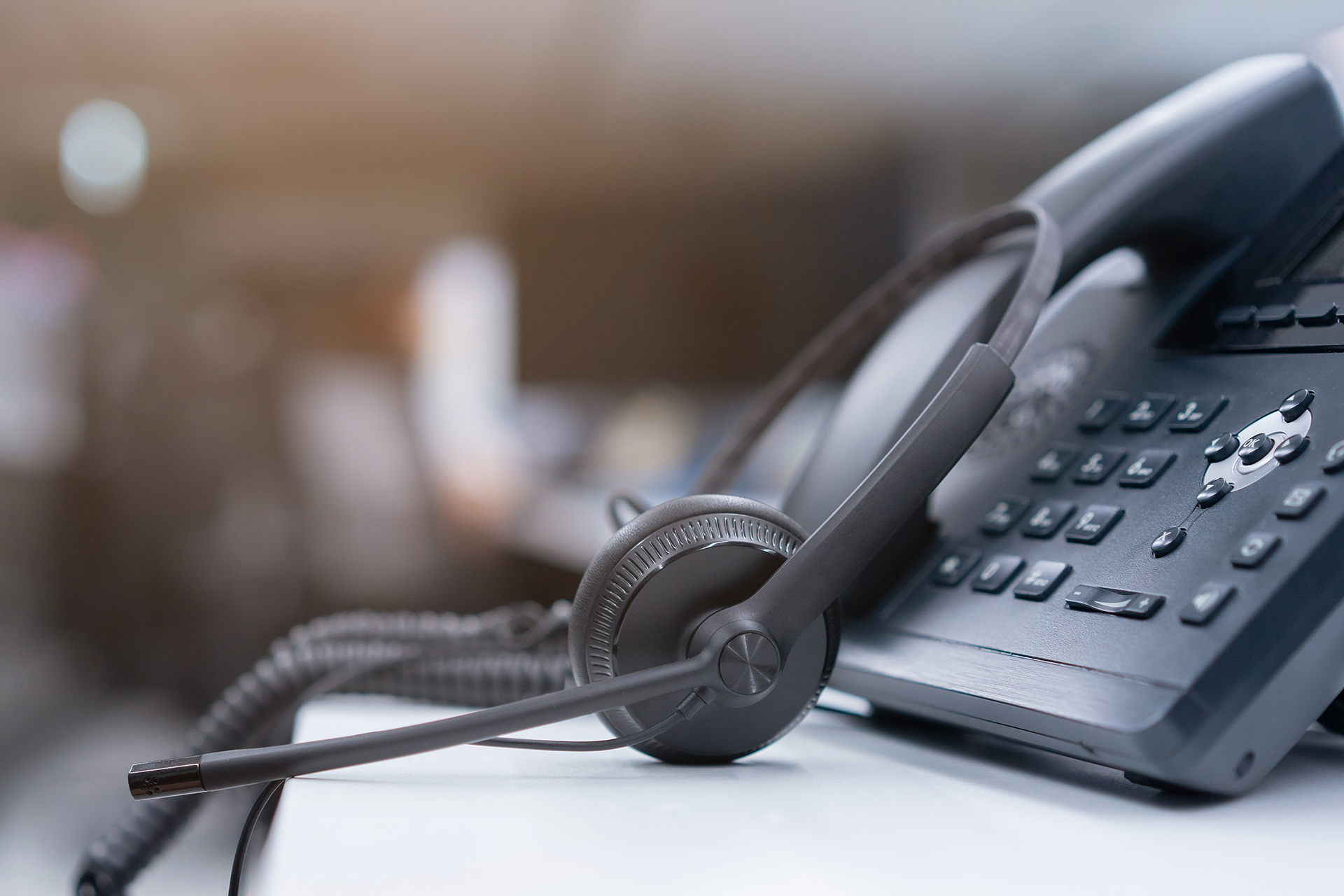 A close up of a telephone with a headset attached to it.