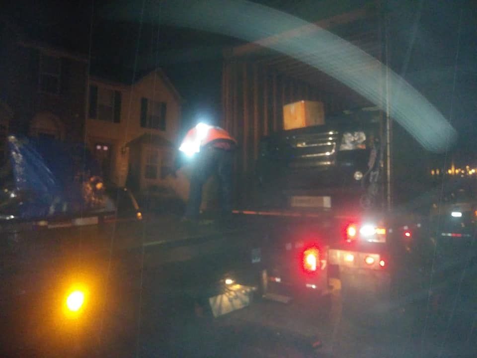 Dark street at night with a truck and bright taillights on a city block
