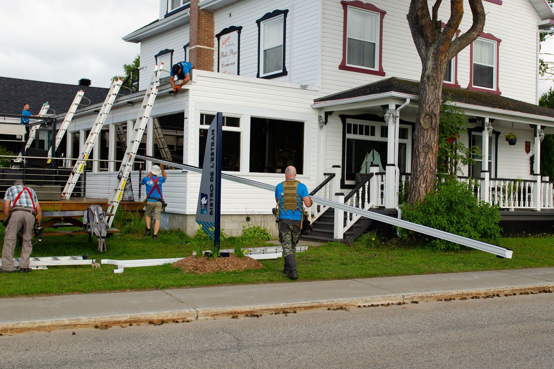 Un groupe d'hommes travaillent sur le toit d'une maison.