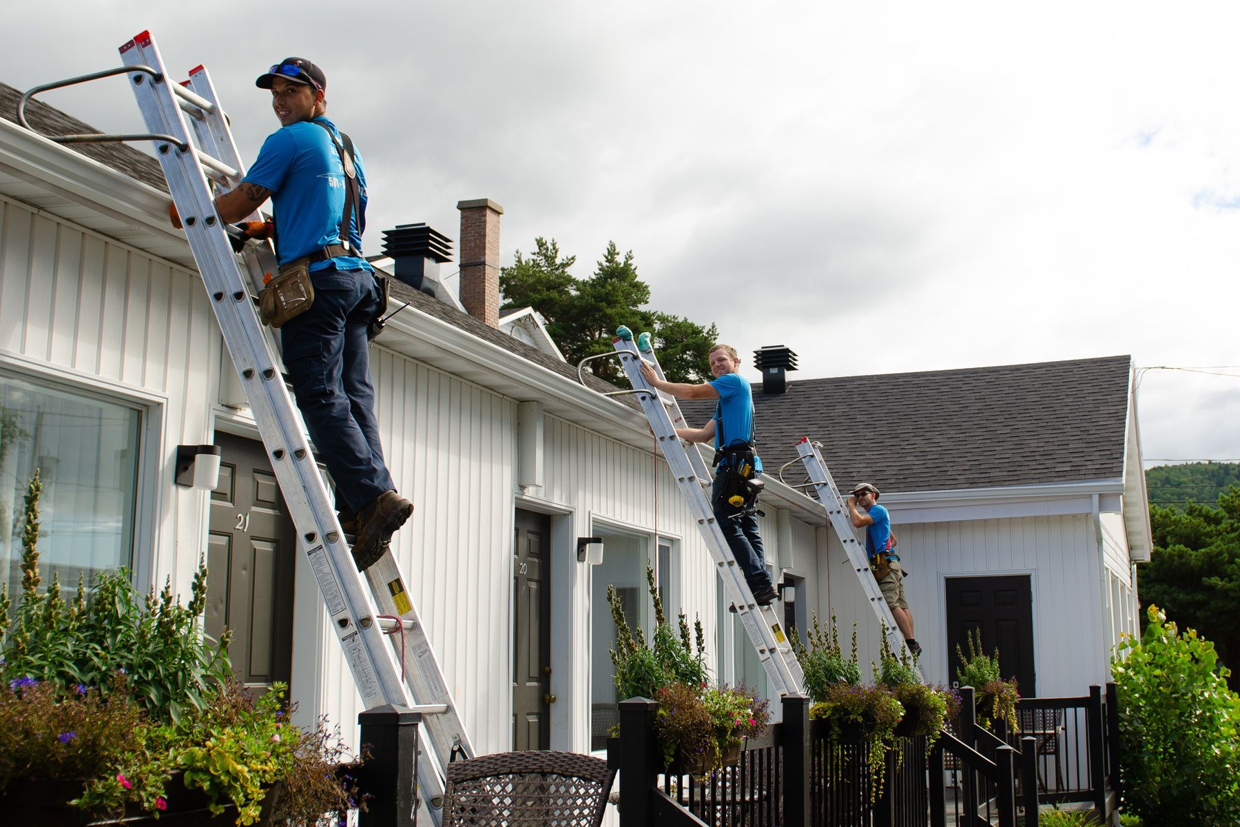 Un groupe d'hommes travaillent sur le toit d'une maison.