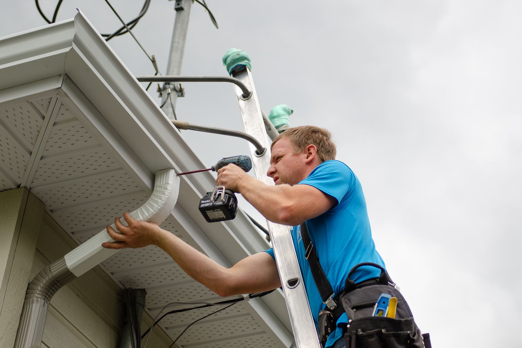 Un groupe d'hommes travaillent sur le toit d'une maison.