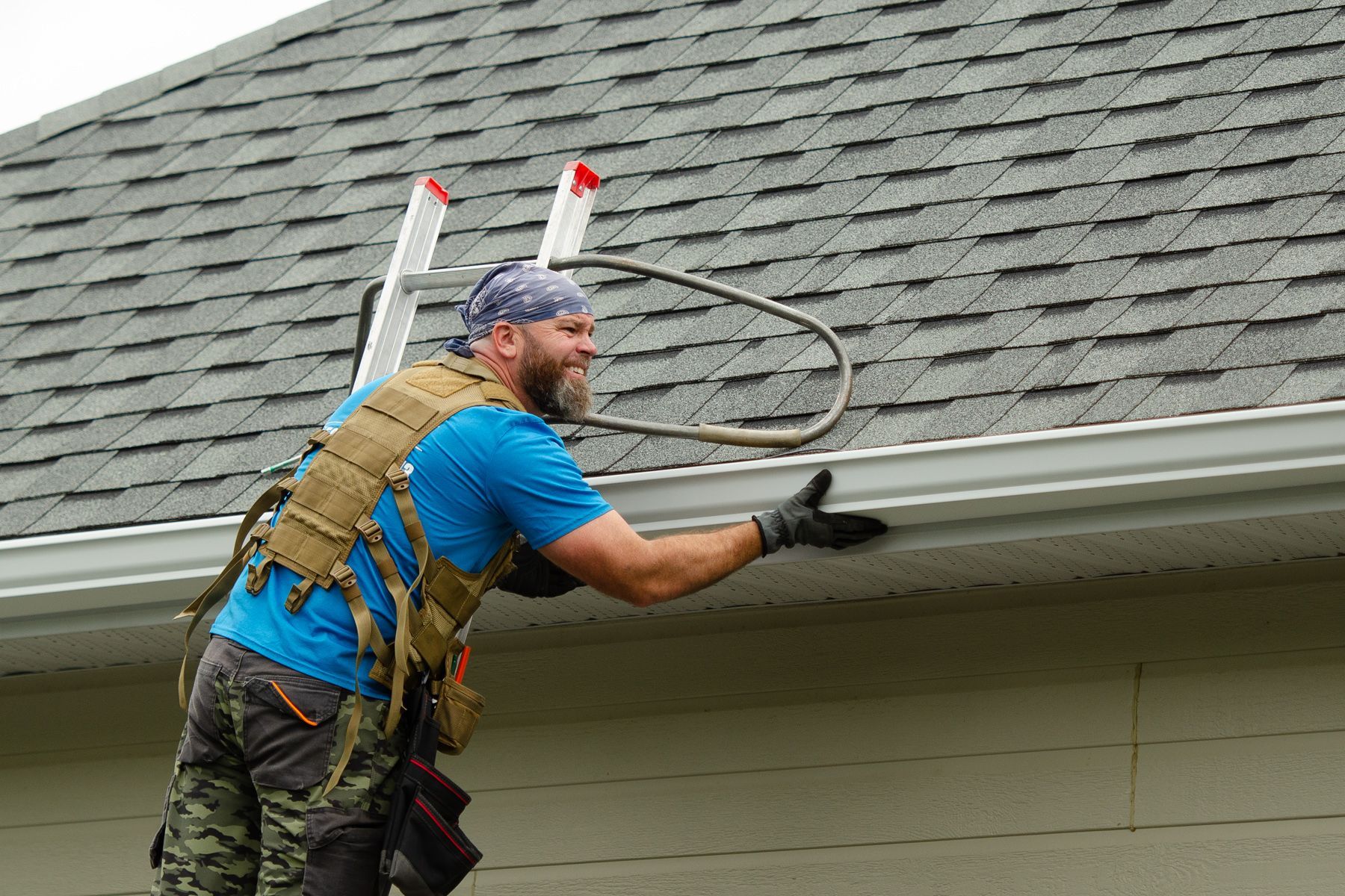 Un groupe d'hommes travaillent sur le toit d'une maison.
