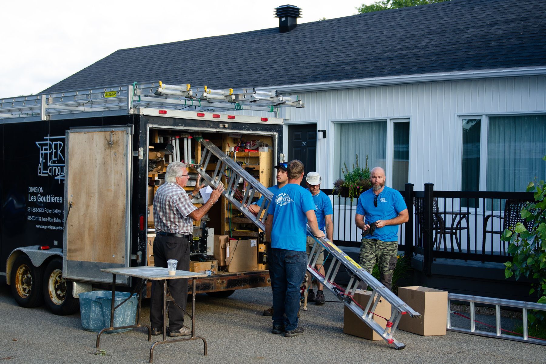 Un groupe d'hommes travaillent sur le toit d'une maison.