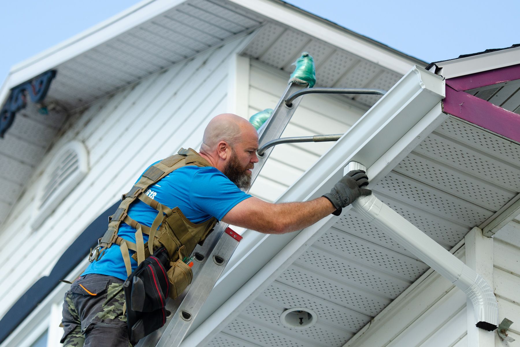 Un groupe d'hommes travaillent sur le toit d'une maison.