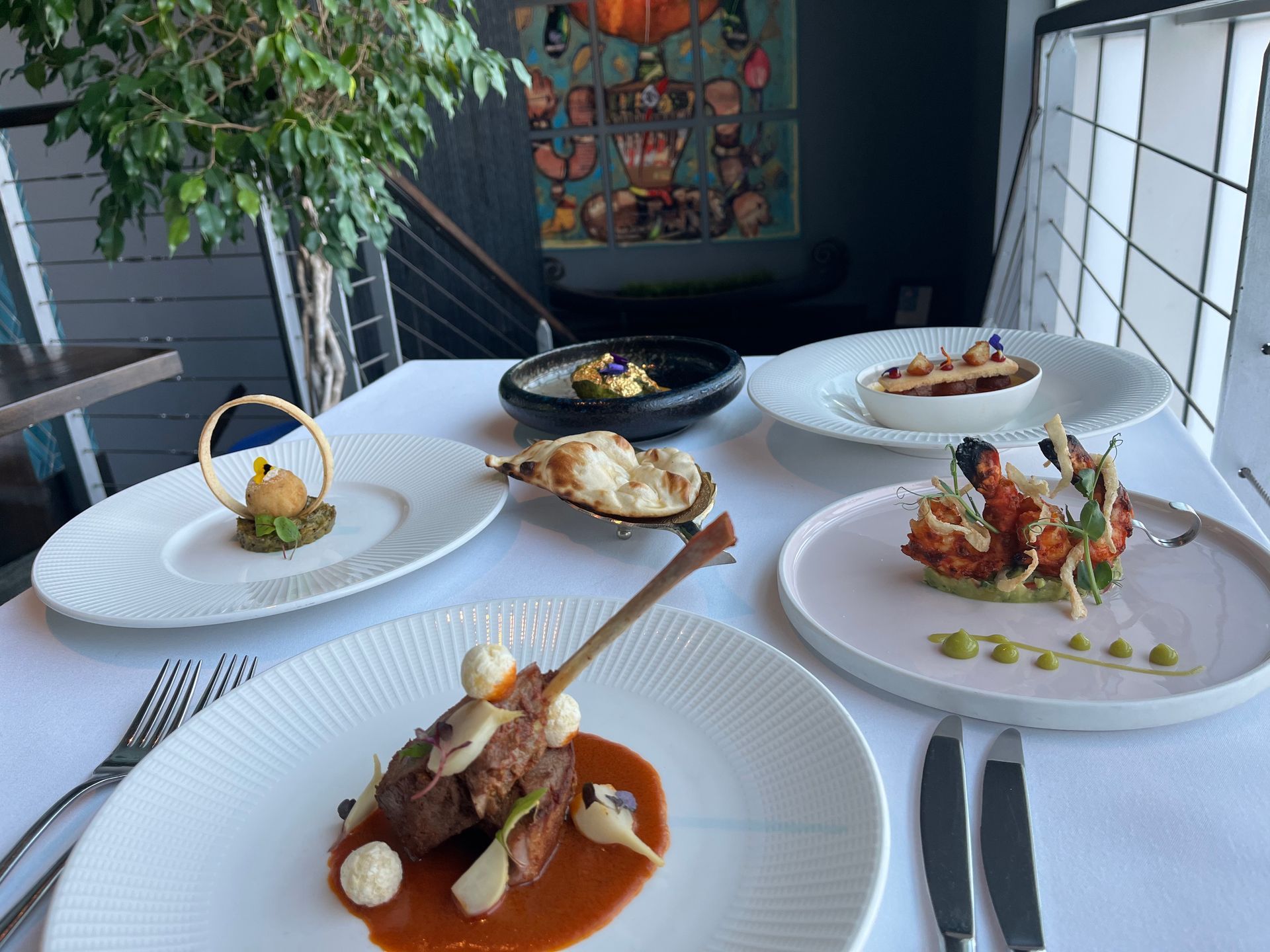 A table topped with plates of food and silverware.