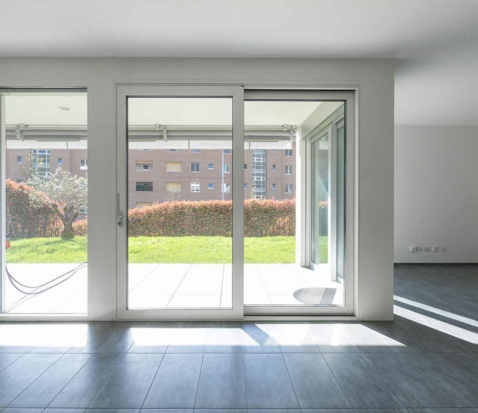 An empty room with sliding glass doors leading to a patio An empty room with sliding glass doors leading to a patio