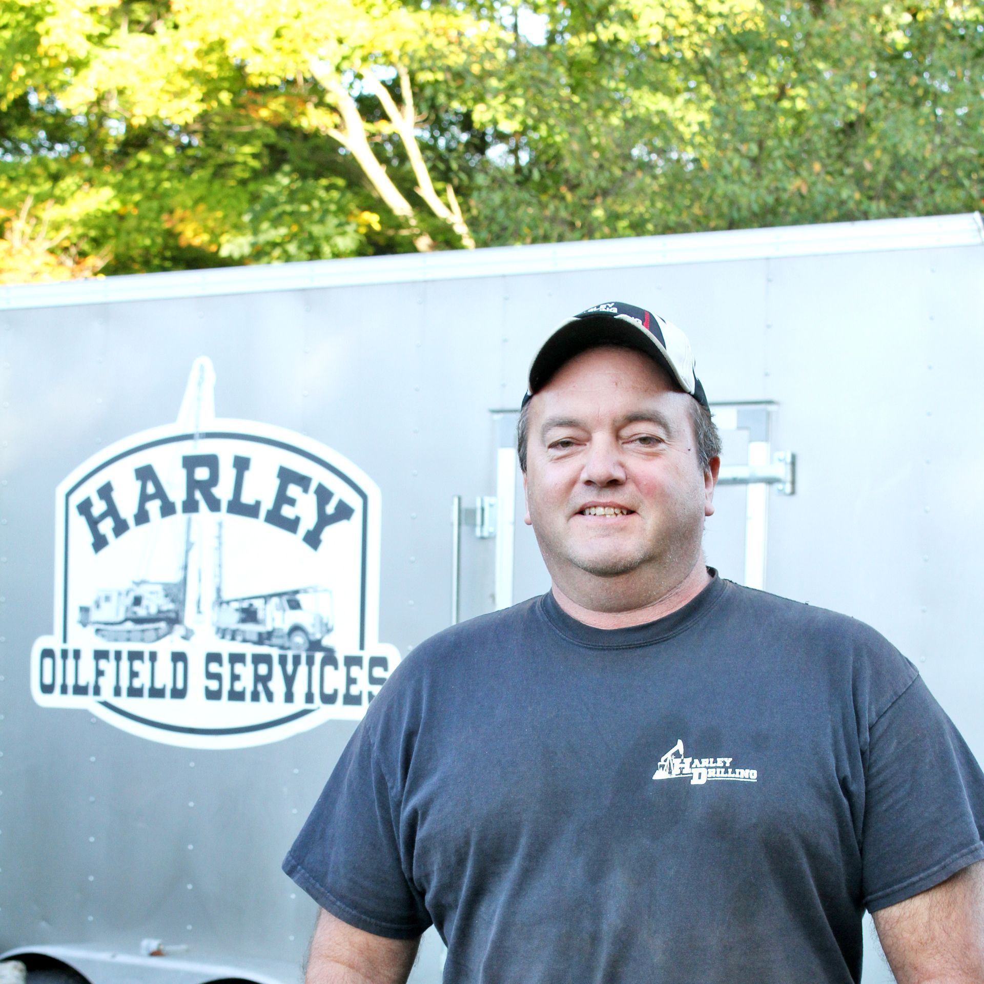 Man in work clothes, stands by a trailer with 
