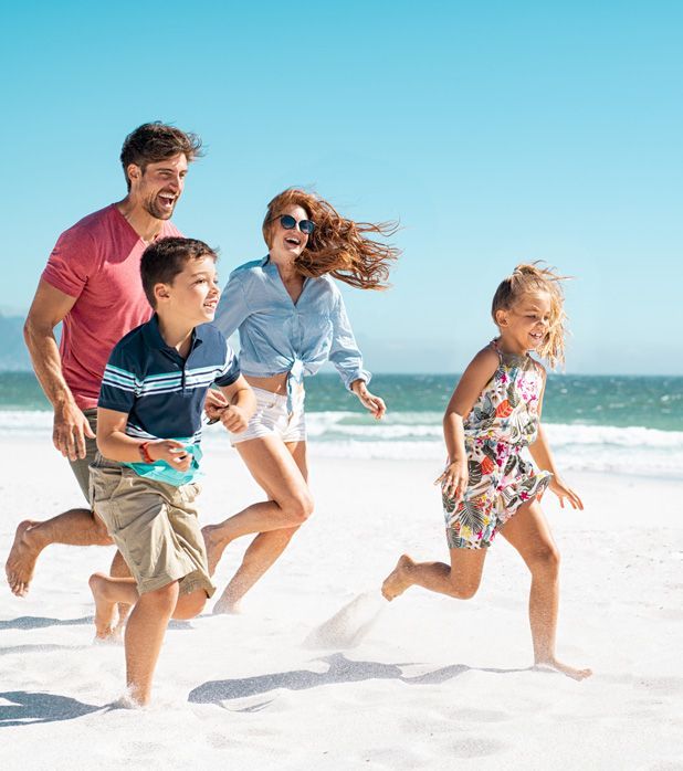 A family running together on a sunny beach, laughing and enjoying time by the ocean. A family running together on a sunny beach, laughing and enjoying time by the ocean.